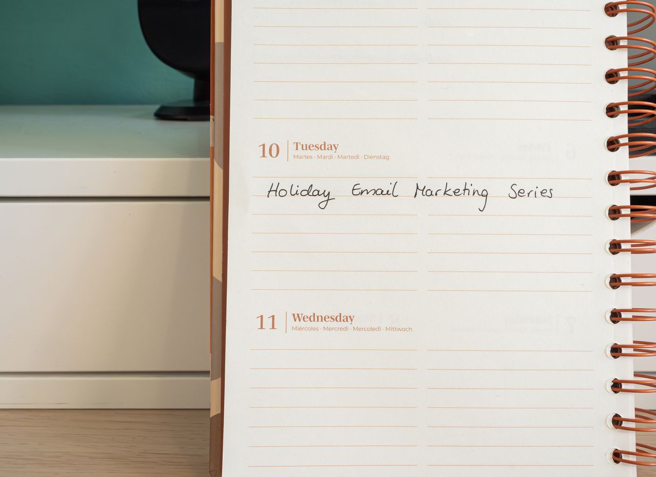 services-04 Planner open on a desk with handwritten Holiday Email Marketing Series note.